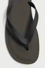 Sandalia de goma color negro, de diseño plano y tiras delgadas en el empeine estilo ojota.