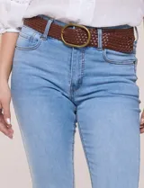 Jean elastizado de tiro alto y pierna semi-oxford, color azul, con diseño clásico de cinco bolsillos y dobladillo en el ruedo. Incluye un cinturón trenzado de cuerina marrón con hebilla metálica dorada.