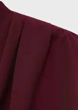 Vestido largo de corte recto y diseño minimalista, confeccionado en tela de poliéster color bordó. Presenta cuello alto, diseño sin mangas y detalles fruncidos en la parte superior, con cierre de cremallera en la espalda y forro interior.