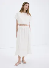 Blusa crop de algodón color blanco con diseño estilo globo, detalles bordados, cuello redondo y manga corta.