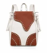 Mochila de cuero vacuno en combinación de colores blanco y marrón, decorada con tachas metálicas plateadas en los bordes de la solapa y en la base inferior. Cuenta con tiras ajustables para la espalda, asa superior y sistema de cierre con cordón ajustable.