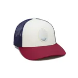 Gorra tipo trucker con frente de color crema, visera curva color bordó y paneles traseros de malla color azul. Presenta un parche circular frontal con diseño de sol y paisaje.