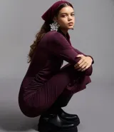 Vestido midi de manga larga en color bordó, con diseño ajustado al cuerpo, cuello redondo y detalle de pliegues asimétricos en uno de los hombros. Presenta una abertura lateral en el ruedo.