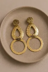 Aros colgantes dorados compuestos por un disco superior texturizado, una pieza central en forma de gota con textura martillada y un aro circular liso en la parte inferior.