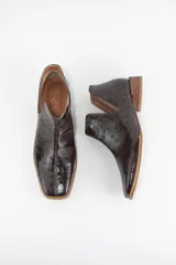 Botin de cuero con acabado grabado efecto avestruz, diseño con aberturas laterales y taco bajo cuadrado.