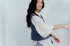 Chaleco de jean azul con bordados y estampado en el interior.