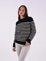 Buzo tejido a rayas horizontales blancas y negras, de corte recto y mangas largas.
