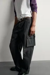 Pantalón cargo de corte relaxed fit, color negro con efecto lavado y estampado de salpicaduras blancas. Cuenta con bolsillos laterales con solapa en las perneras, pinzas en las rodillas y cierre frontal con botón y cremallera.
