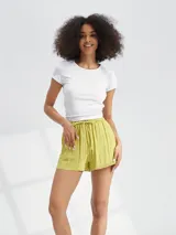 Short de tela liviana con textura arrugada, color negro, con cintura elástica y cordón ajustable.