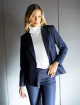 Blazer de tencel color azul marino con cuello de solapa y cierre frontal de un solo botón. Presenta bolsillos delanteros simulados con detalle de vivo trenzado y un diseño estructurado de calce entallado.