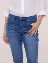 Jean slim skinny de tiro medio en denim azul con proceso de lavado, calce ajustado y largo al tobillo. Cuenta con pretina con presillas, bolsillos delanteros y traseros, y acceso frontal con botón y cierre.