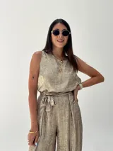 Conjunto de musculosa y pantalón palazzo color dorado brillante. La musculosa es sin mangas y el pantalón es de corte ancho con cintura alta.