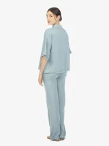 Camisa celeste de manga corta con botones en el frente y un bolsillo en el pecho.