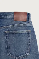 Pantalón jeans de corte recto, color celeste claro con efecto lavado, de cinco bolsillos y tiro medio.