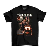 Remera negra de algodón con estampado gráfico frontal inspirado en Jurassic Park, que presenta un dinosaurio, un vehículo todoterreno y el texto 'Enjoy the Ride'.