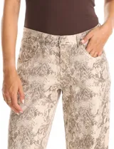 Jean de corte wide leg con estampado animal print de serpiente en tonos beige y gris. Presenta diseño clásico de cinco bolsillos, presillas para cinturón y cierre frontal con botón metálico.