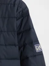 Campera puffer de diseño ligero, color verde militar, con cierre frontal completo y cuello alto. Presenta un acabado acolchado horizontal y puños elásticos.