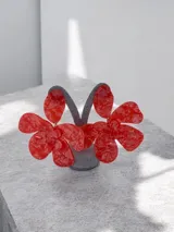 Aros colgantes de gran tamaño con diseño de flor, realizados en resina roja con efecto marmolado.