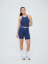 Top deportivo Umbro modelo Kia, color azul marino con detalles en gris en el cuello y sisas. Cuenta con logo estampado en el pecho y diseño de espalda deportiva.