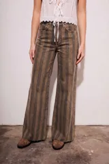 Jean de corte wide leg con diseño de rayas verticales en tonos tierra. Presenta tiro medio, cinco bolsillos y ruedo desflecado.
