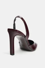 Zapato de tacón tipo sandalia destalonada con tira trasera, acabado en punta cuadrada y tacón fino alto.