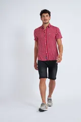 Camisa de manga corta con diseño a rayas verticales en color azul marino y blanco. Presenta cuello clásico, cartera abotonada frontal y logo bordado en el pecho. Posee un corte slim fit.