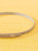 Cinturón delgado de cuero color azul marino, con hebilla minimalista de metal oscuro y pasador doble.