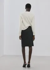 Sweater de punto color blanco crudo, con cuello redondo y mangas largas.