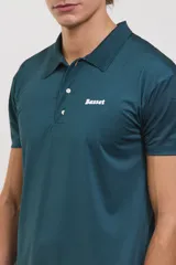 Chomba deportiva de manga corta, color verde oscuro, con cuello polo y cierre frontal de dos botones. Presenta un diseño entallado con tejido técnico transpirable y elástico, ideal para actividades deportivas.