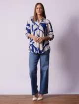 Camisa de manga larga con estampado abstracto en tonos verde y blanco. Cuello con solapa y abertura central con botones. Largo de manga regulable con presilla y botón. Terminación de ruedo anudada opcional.