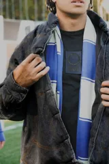 Bufanda larga de tejido de punto con rayas horizontales anchas en color blanco y azul.