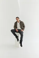 Sobrecamisa de paño marrón con diseño escocés a cuadros. Tiene cuello clásico, cierre frontal con botones, dos bolsillos de parche en el pecho y corte recto.