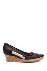 Zapato de taco corrido tipo cuña, confeccionado en cuero negro con aberturas laterales. Presenta una base de corcho y detalle de yute en la puntera.