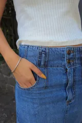 Falda larga de jean azul claro, con tajo trasero, pretina con doble botón y cierre metálico.