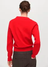 Jersey de punto fino color rojo, con cuello en V con solapa tipo polo y manga larga, de diseño recto.