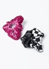 Set de dos scrunchies, uno de terciopelo color fucsia y otro con un lado de cuero sintético negro y otro de tela a cuadros blancos y negros.