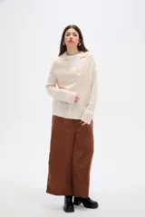 Sweater de punto color azul, con cuello polo y escote en V, de manga larga y diseño holgado.