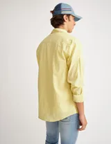 Camisa amarilla de manga larga confeccionada en tela tipo lino, con bolsillo en el pecho, botones de pasta y calce clásico.