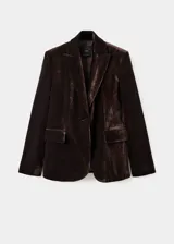 Blazer de corte recto confeccionado en tejido de terciopelo color marrón oscuro. Presenta cuello con solapas de muesca, cierre frontal con un botón, mangas largas con puños abotonados y dos bolsillos laterales con solapa. Incluye forro interior.