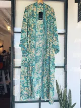 Kimono largo de tela estampada con motivos abstractos en tonos azules, verdes y beige. Diseño de manga ancha y corte recto, sin cierres.