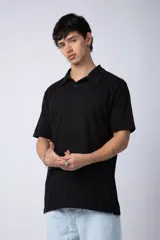 Chomba de manga corta en color blanco, con cuello clásico y cierre frontal de dos botones. Presenta un corte recto y diseño minimalista.