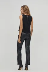 Top negro sin mangas de gamuza de cabra con apliques tribales de cuero de oveja al tono. Tiene cuello a la base y cierre metálico en la espalda.