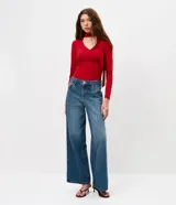 Blusa entallada de microfibra color blanco, con escote en V, mangas largas y detalle de frunces en los laterales. Presenta un lazo integrado en el cuello que permite anudarlo, aportando un toque sofisticado al diseño.