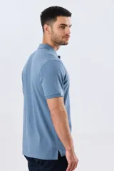 Remera polo de piqué de algodón color azul, de manga corta, con cuello camisero, cierre frontal de dos botones y pequeño logo bordado en el pecho.