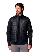 Chaqueta híbrida para hombre con cuerpo acolchado y mangas de tejido softshell liso. Presenta cierre frontal completo, cuello alto y logo de la marca estampado en el pecho. Diseñada con tecnología repelente al agua y aislamiento térmico sintético.