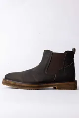 Bota tipo Chelsea de cuero color marrón oscuro, con paneles laterales elásticos y suela de goma con efecto madera.