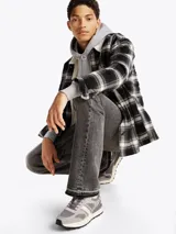 Zapatillas Tommy Jeans grises de corte bajo, con exterior de ante y malla, detalles distintivos de la marca, suela de goma dentada y cierre con cordones.