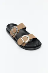 Sandalia tipo slide color tostado, con doble tira ancha y hebillas metálicas plateadas con diseño texturado. Su base es ergonómica y liviana, de color negro.