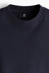 Remera oversize color negro de algodón con cuello redondo y mangas cortas amplias.