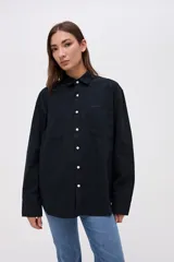 Sobrecamisa de algodón color marrón, con cuello solapa, cierre frontal de botones y bolsillos frontales en el pecho.